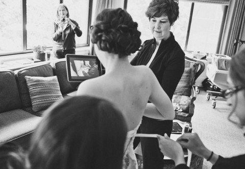 Bride uses an iPad to film her dress being tied